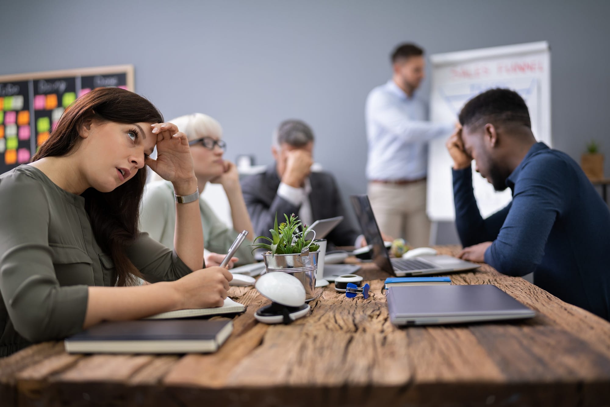 Business team sitting in a meeting look like they need culture change management.